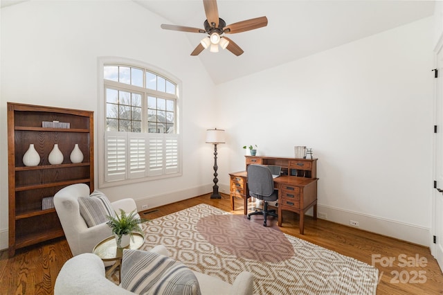 home office with baseboards, wood finished floors, a ceiling fan, and vaulted ceiling