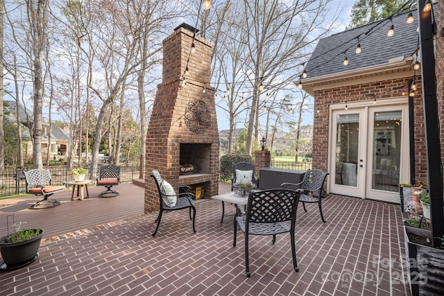 view of patio featuring an outdoor brick fireplace and fence