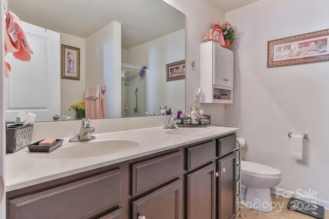 bathroom with double vanity, a stall shower, a sink, and toilet