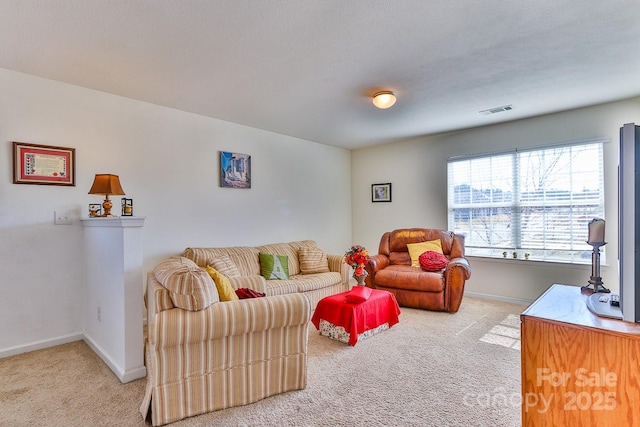 carpeted living area featuring visible vents and baseboards