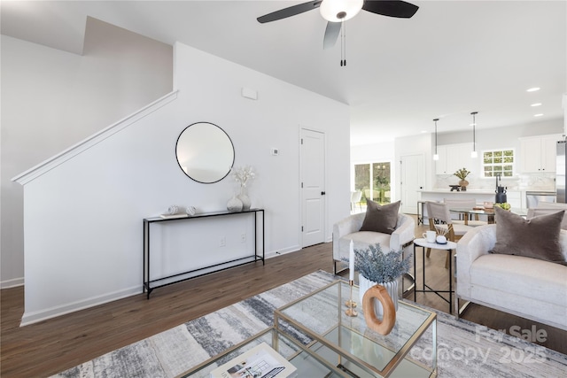 living area with a ceiling fan, baseboards, recessed lighting, and wood finished floors