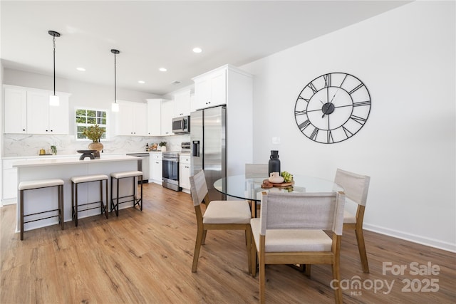 dining room with light wood-style floors and recessed lighting
