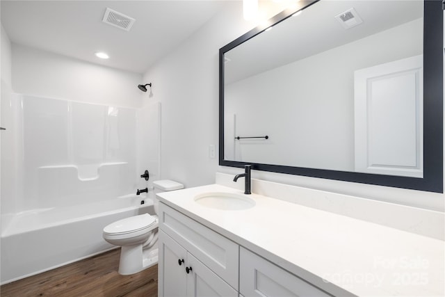 full bathroom with toilet, vanity, visible vents, and wood finished floors