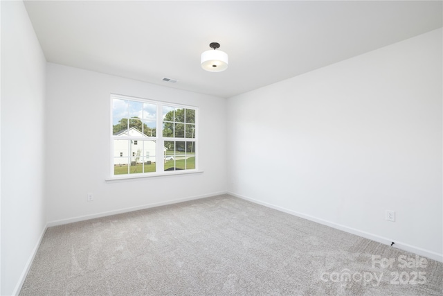 carpeted empty room featuring visible vents and baseboards