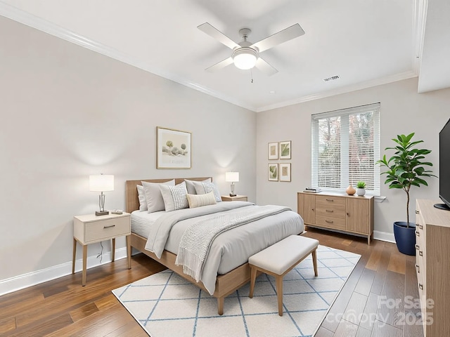 bedroom with baseboards, hardwood / wood-style flooring, and crown molding