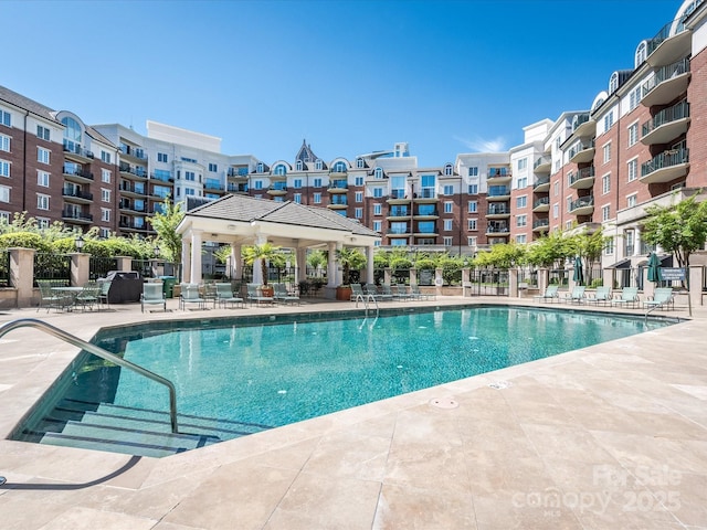 pool with a patio and fence