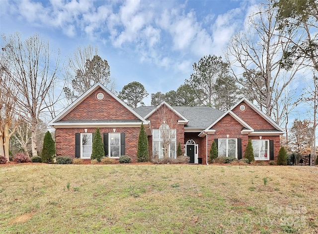 view of front of house with brick siding and a front lawn