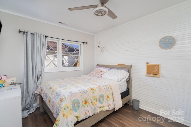 bedroom featuring ornamental molding, a ceiling fan, visible vents, and wood finished floors