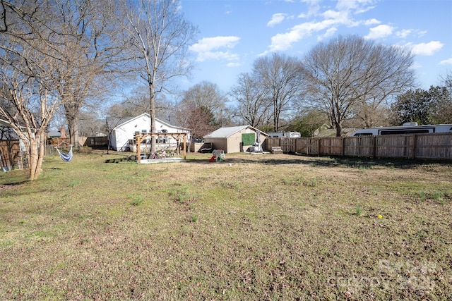 view of yard with an outbuilding, fence, and a storage unit