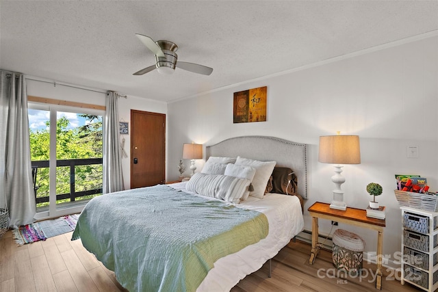 bedroom featuring access to exterior, ornamental molding, a textured ceiling, and wood finished floors