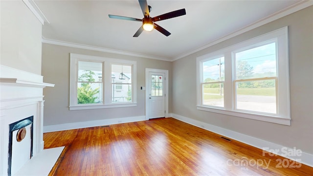 unfurnished living room with crown molding, baseboards, visible vents, and hardwood / wood-style floors