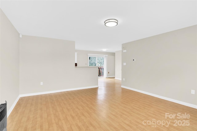 unfurnished room featuring light wood finished floors and baseboards