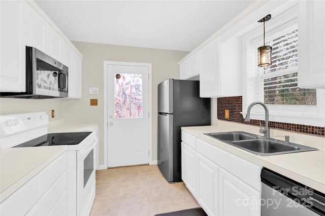 kitchen with stainless steel appliances, plenty of natural light, white cabinets, and a sink