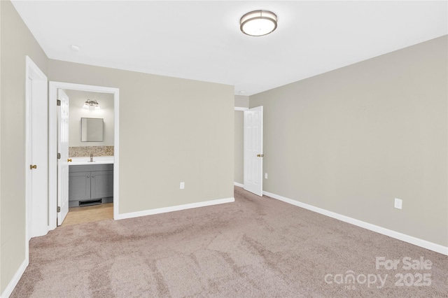 unfurnished bedroom featuring light carpet, visible vents, baseboards, and a sink