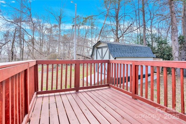 wooden deck with a shed and an outdoor structure