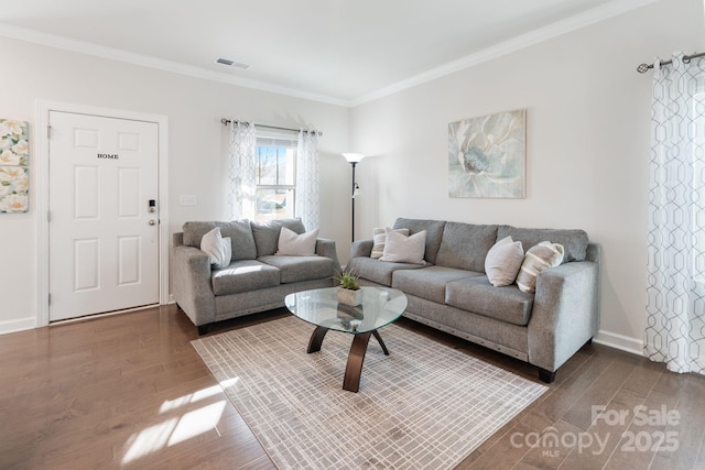 living area featuring visible vents, baseboards, wood finished floors, and crown molding