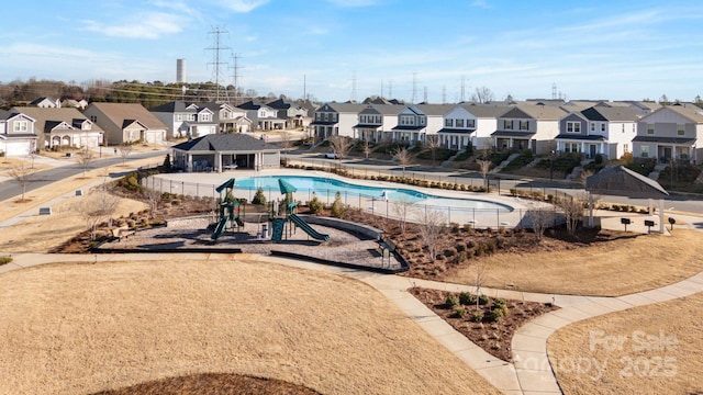 view of swimming pool with playground community, a residential view, and fence