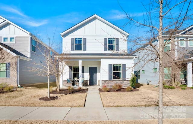 view of front of property featuring a porch, stone siding, and board and batten siding