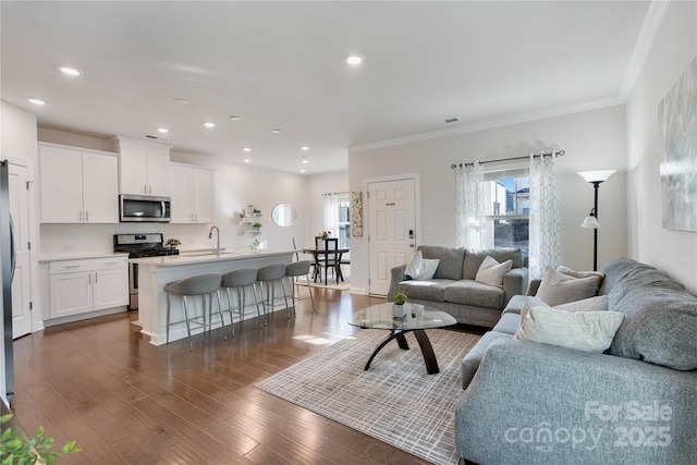 living area with recessed lighting, crown molding, and dark wood-style flooring