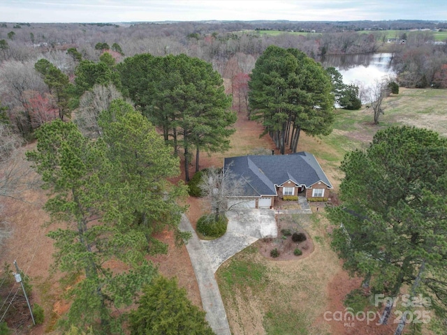 aerial view with a wooded view and a water view