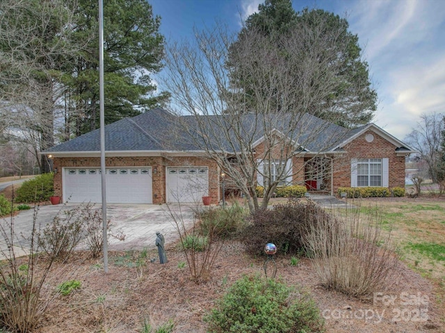 ranch-style house featuring concrete driveway, an attached garage, brick siding, and roof with shingles