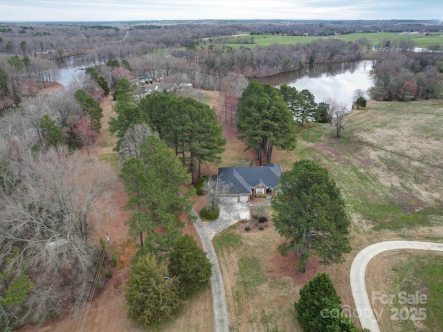 drone / aerial view featuring a view of trees and a water view