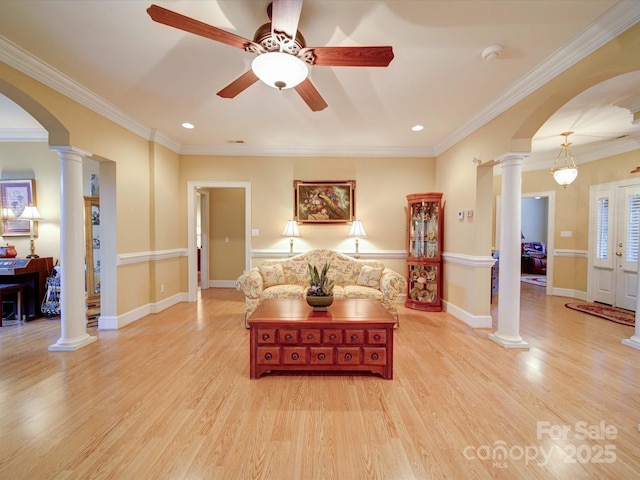 living room featuring decorative columns, arched walkways, and wood finished floors