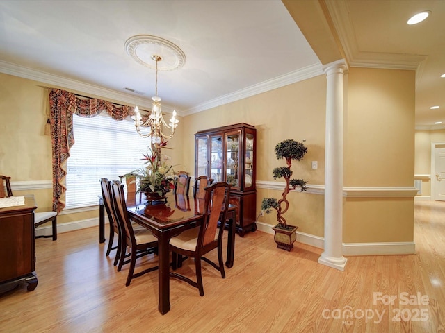 dining area featuring visible vents, light wood-style flooring, crown molding, and decorative columns