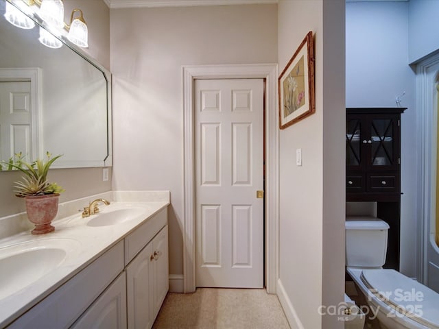 full bathroom with a sink, baseboards, toilet, and double vanity