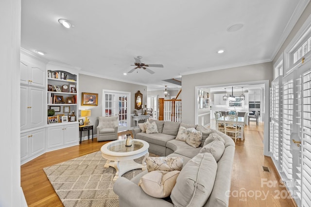 living area featuring light wood-style floors, recessed lighting, and ornamental molding