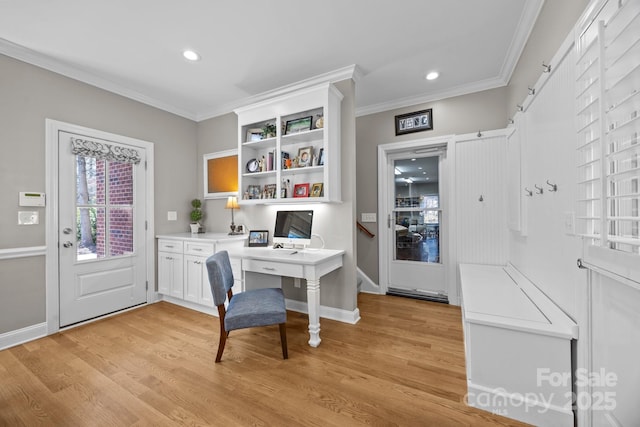 office area with ornamental molding, light wood-type flooring, and built in desk