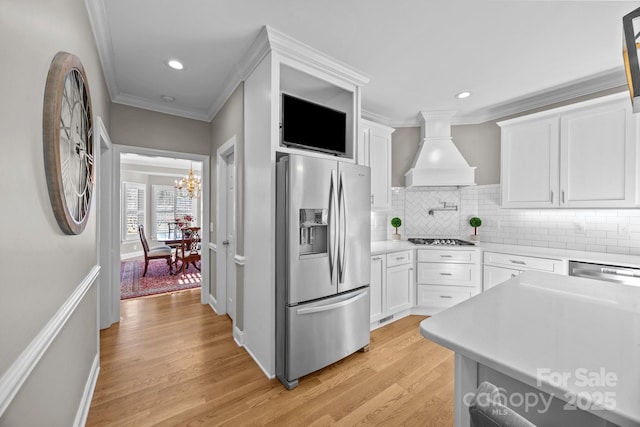 kitchen featuring light countertops, appliances with stainless steel finishes, custom exhaust hood, and white cabinets