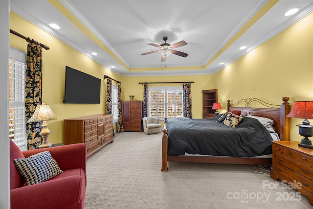 carpeted bedroom with ornamental molding, a tray ceiling, ceiling fan, and recessed lighting