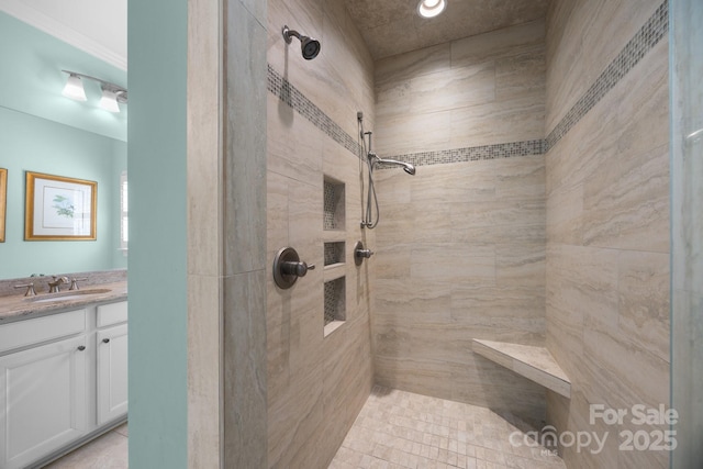 bathroom with tiled shower and vanity