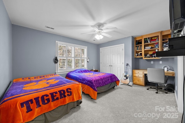 carpeted bedroom with a ceiling fan, a closet, and visible vents