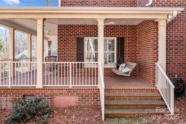 entrance to property featuring covered porch and brick siding