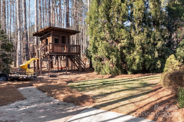 exterior space featuring a wooded view and a yard