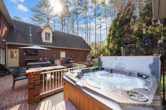 wooden terrace with a hot tub, outdoor dining area, and a patio