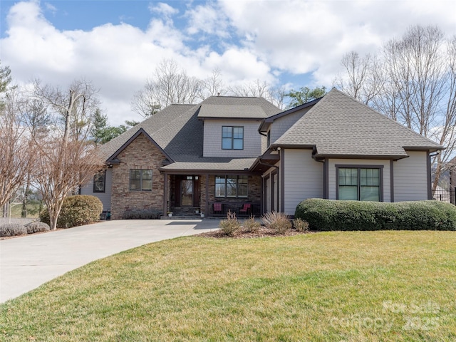 view of front of property featuring roof with shingles and a front lawn