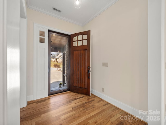 entrance foyer with light wood finished floors, baseboards, visible vents, and ornamental molding