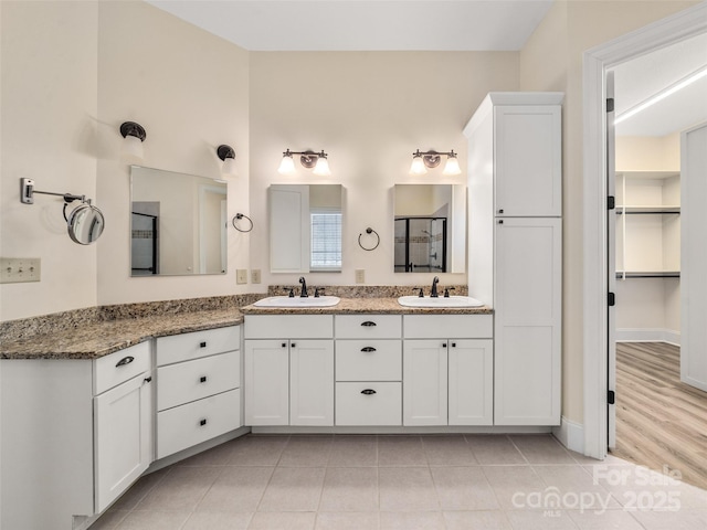 full bath with tile patterned flooring, a sink, and double vanity