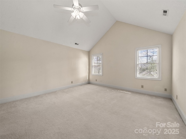 unfurnished room featuring visible vents, a ceiling fan, light carpet, high vaulted ceiling, and baseboards