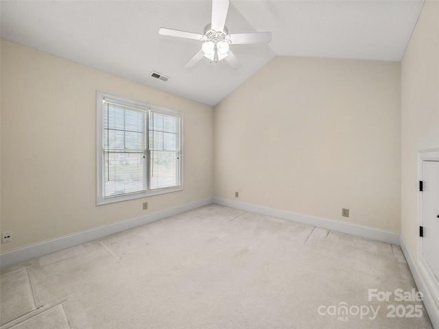 empty room with light carpet, baseboards, visible vents, a ceiling fan, and vaulted ceiling