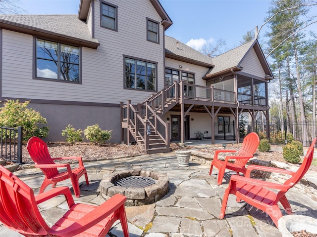 rear view of property with a patio, a fire pit, a sunroom, stairway, and a wooden deck