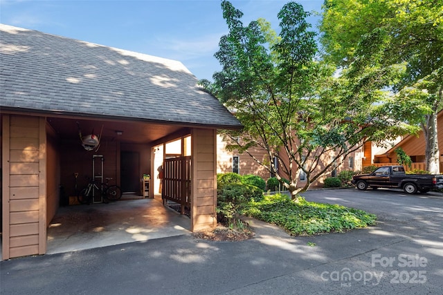 view of side of property with roof with shingles