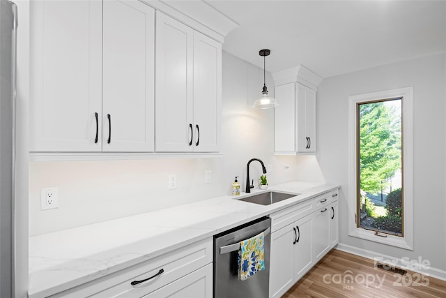 kitchen featuring light stone counters, white cabinetry, a sink, stainless steel dishwasher, and decorative light fixtures