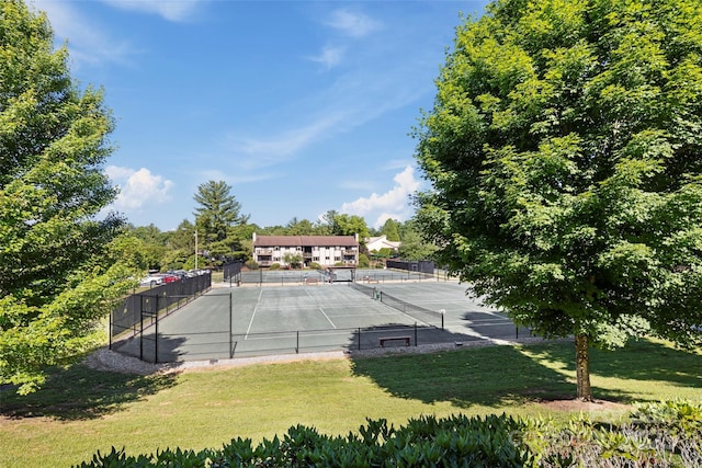 view of sport court featuring a yard and fence