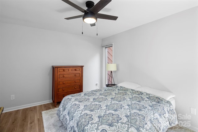 bedroom featuring a ceiling fan, wood finished floors, and baseboards