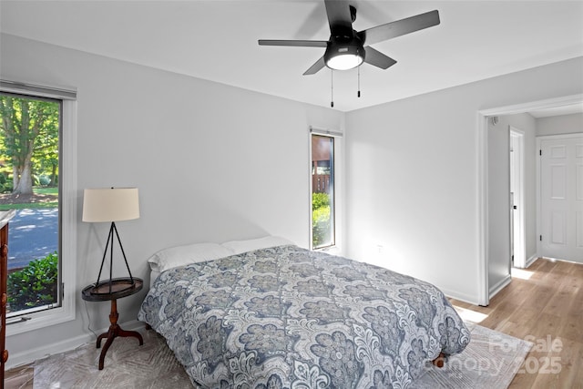 bedroom with baseboards, ceiling fan, and light wood finished floors