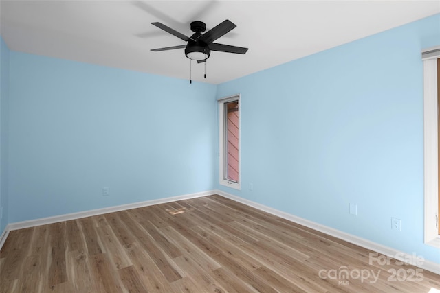 empty room with a ceiling fan, baseboards, and wood finished floors